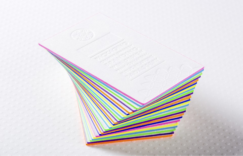 Business card with vibrant painted colored edges showing multi-color edge finishing technique